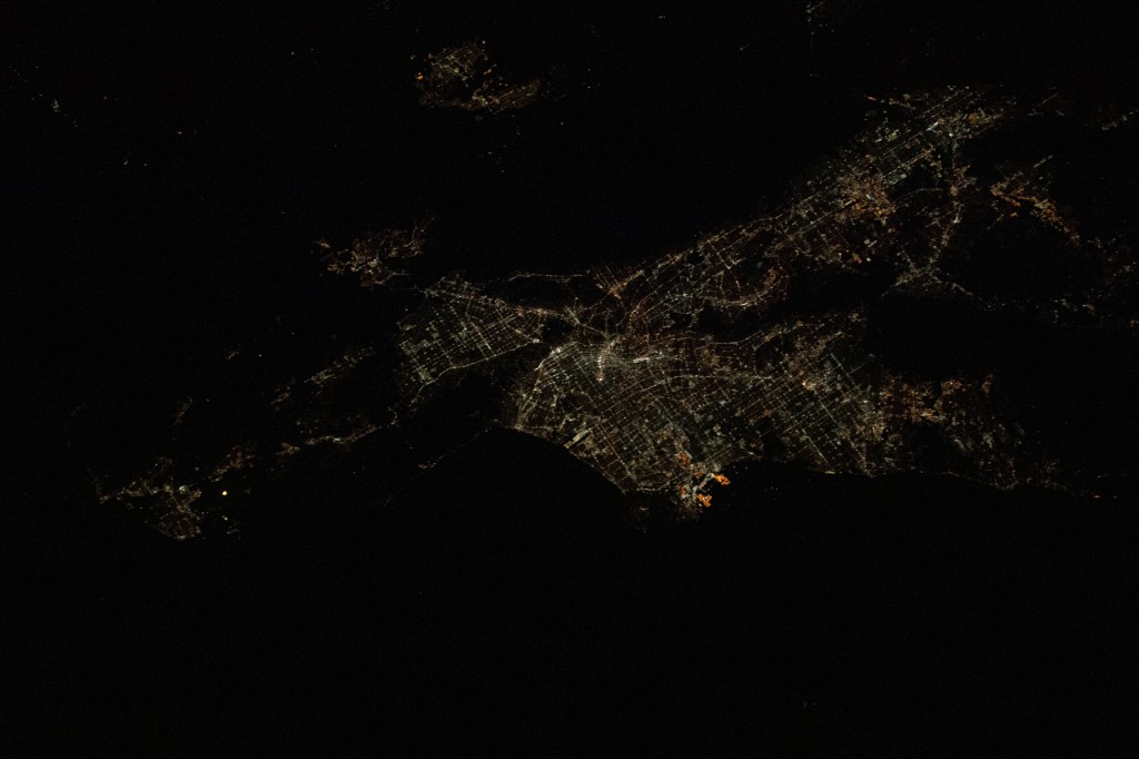 Los Angeles, California is pictured at night as the International Space Station was orbiting 257 miles above the Pacific Ocean and about 215 miles southwest of the L.A. coastline. The bright orange lights at the center are Terminal Island and the Port of Los Angeles.