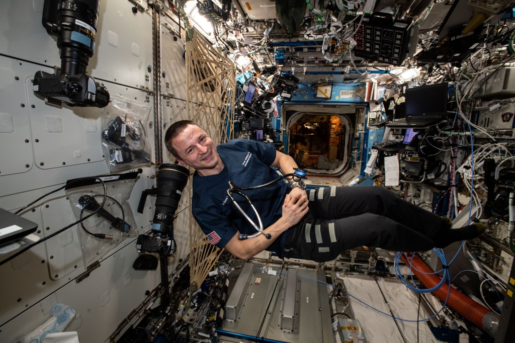 NASA astronaut Andrew Morgan poses for a portrait with a stethoscope for medical checks inside the U.S. Destiny laboratory module after an exercise session.