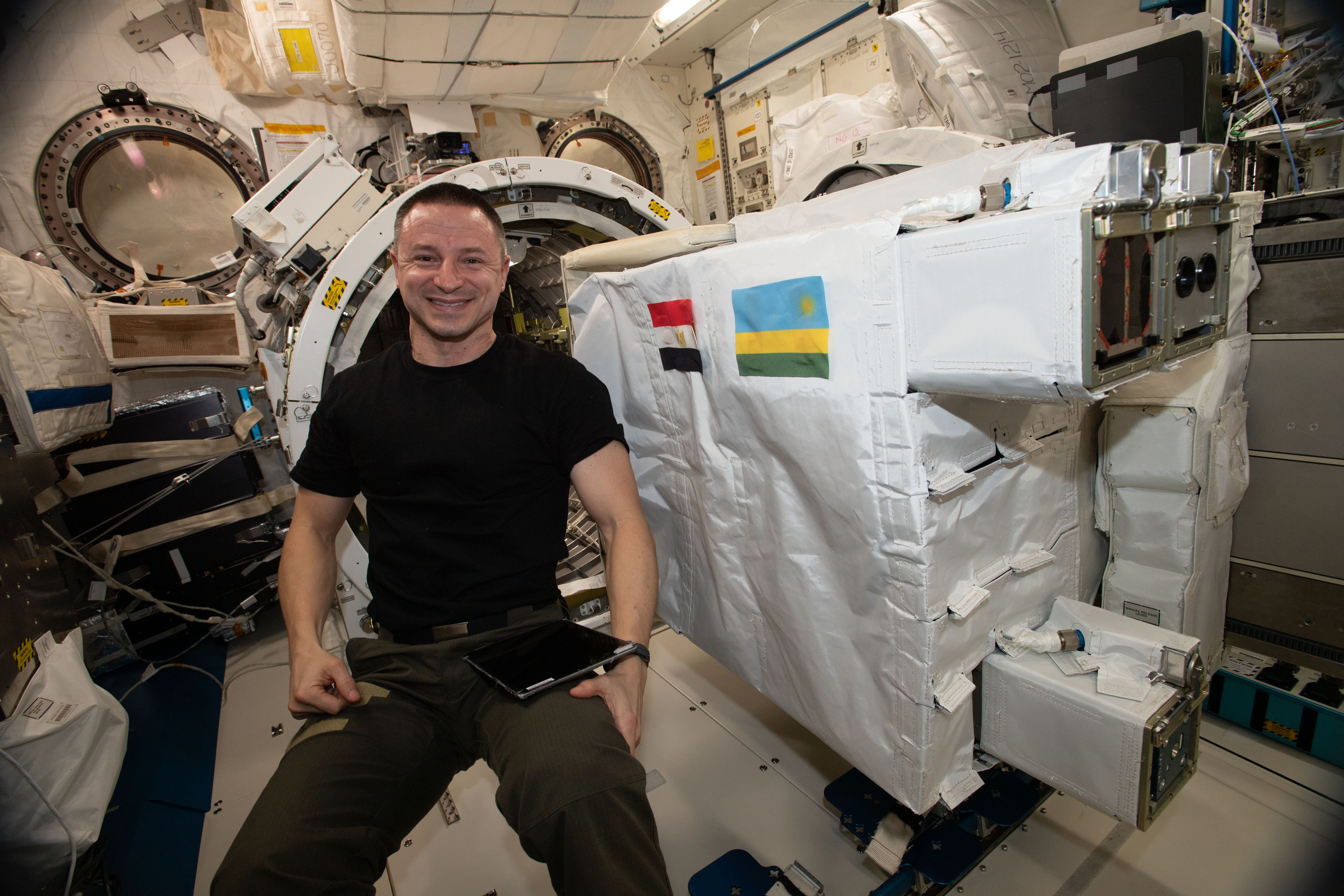 NASA astronaut Andrew Morgan works inside Japan's Kibo laboratory module setting up a small satellite deployer loaded with three CubeSats developed by the nations of Japan, Rwanda and Egypt. The deployer was placed inside Kibo's airlock before the Japanese robotic arm grappled it and moved it outside Kibo where it would eject all three CubeSats into Earth orbit.