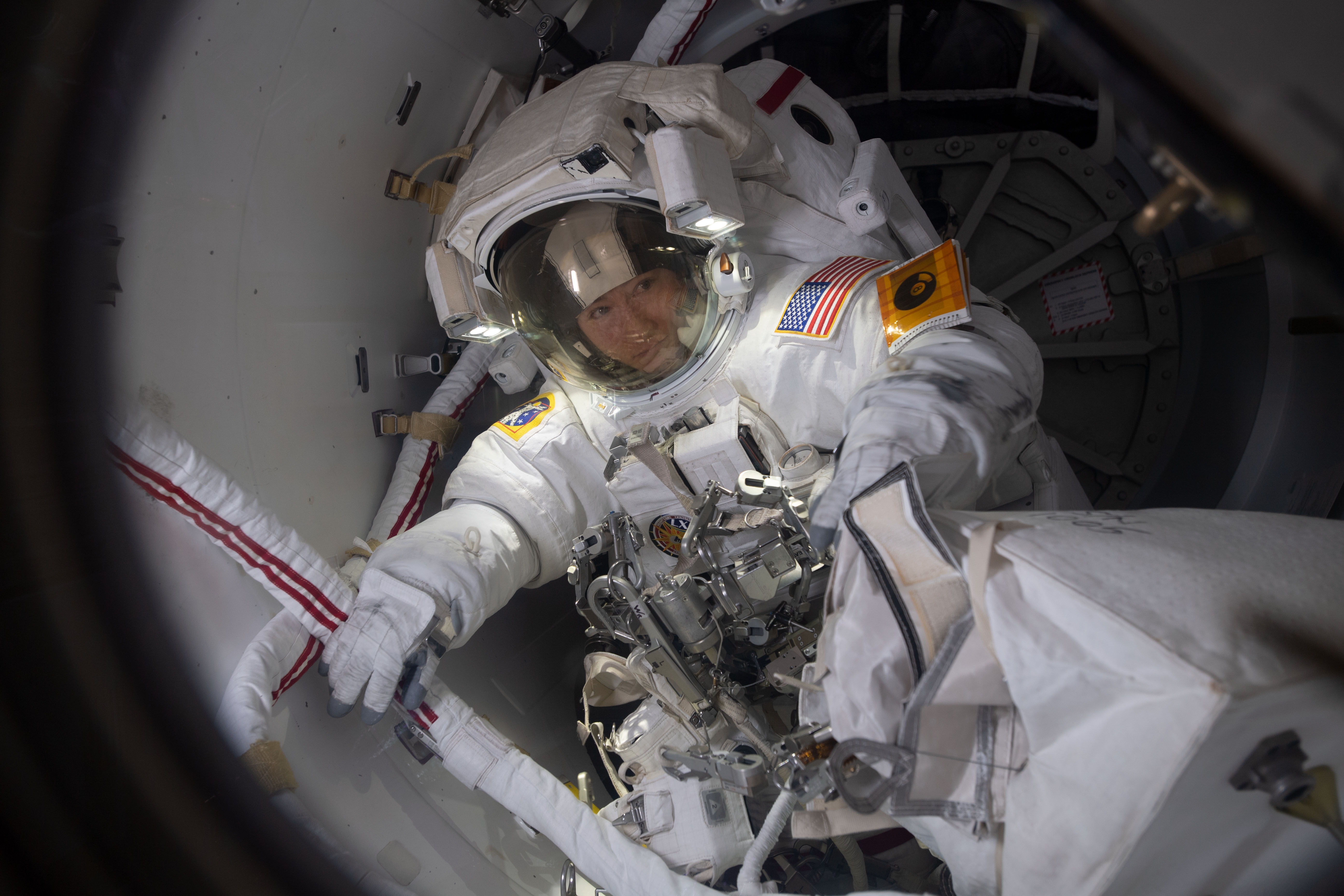 NASA astronaut Christina Koch prepares to exit the crew lock portion of the Quest airlock into the vacuum of space. She and fellow NASA astronaut Jessica Meir (out of frame) conducted a spacewalk for seven hours and 17 minutes to swap a failed battery charge-discharge unit (BCDU) with a spare during the first all-woman spacewalk. The BCDU regulates the charge to the batteries that collect and distribute solar power to the orbiting lab’s systems.