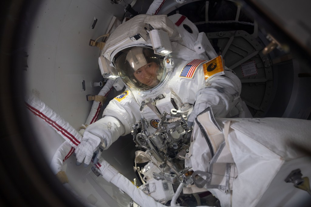 NASA astronaut Christina Koch prepares to exit the crew lock portion of the Quest airlock into the vacuum of space. She and fellow NASA astronaut Jessica Meir (out of frame) conducted a spacewalk for seven hours and 17 minutes to swap a failed battery charge-discharge unit (BCDU) with a spare during the first all-woman spacewalk. The BCDU regulates the charge to the batteries that collect and distribute solar power to the orbiting lab’s systems.