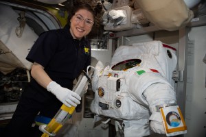 NASA astronaut Christina Koch works on a U.S. spacesuit, with a patch of the Italian flag on the left shoulder, that Commander Luca Parmitano of ESA (European Space Agency) wore during a spacewalk on Dec. 2, 2019.