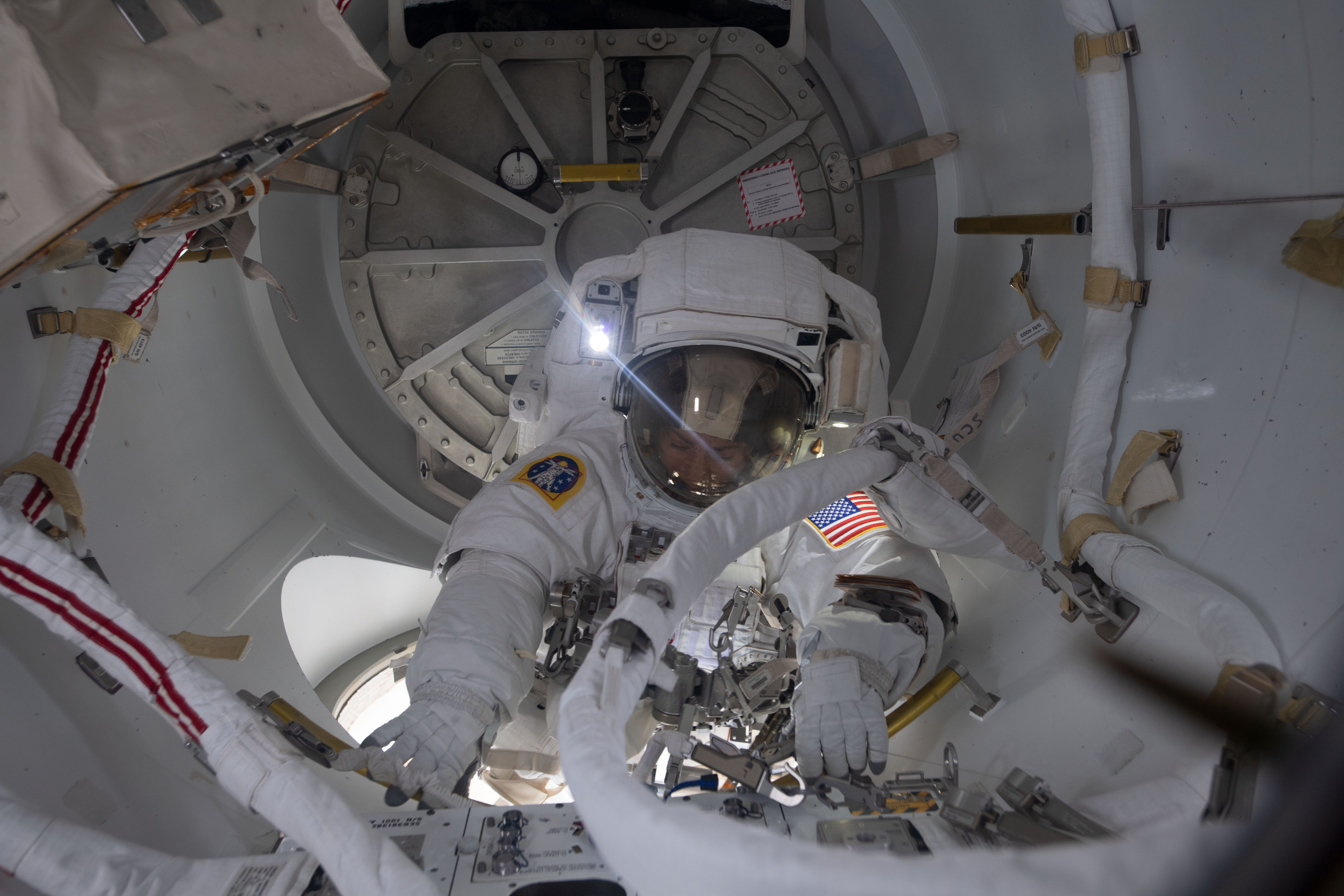 NASA astronaut Jessica Meir prepares to exit the crew lock portion of the Quest airlock into the vacuum of space. She and fellow NASA astronaut Christina Koch (out of frame) conducted a spacewalk for seven hours and 17 minutes to swap a failed battery charge-discharge unit (BCDU) with a spare during the first all-woman spacewalk. The BCDU regulates the charge to the batteries that collect and distribute solar power to the orbiting lab’s systems.