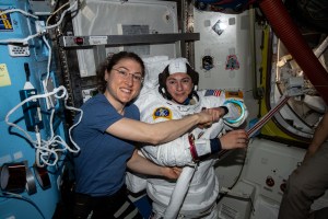 NASA astronaut Christina Koch (left) poses for a portrait with fellow Expedition 61 Flight Engineer Jessica Meir of NASA who is inside a U.S. spacesuit for a fit check. The duo is preparing for their first spacewalk together planned for Oct. 18 to replace a failed power controller on the International Space Station's P6 truss structure.