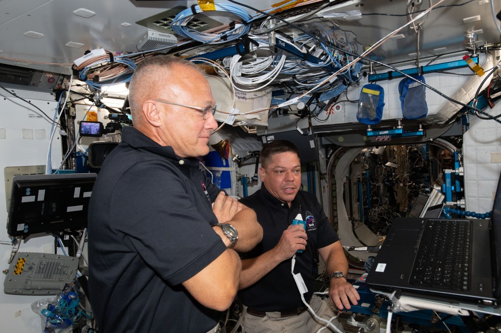 NASA astronauts Doug Hurley (foreground) and Bob Behnken, who flew the Crew Dragon spacecraft to the International Space Station during SpaceX Demonstration Mission-2, are pictured briefing mission controllers about their experience in the new vehicle.