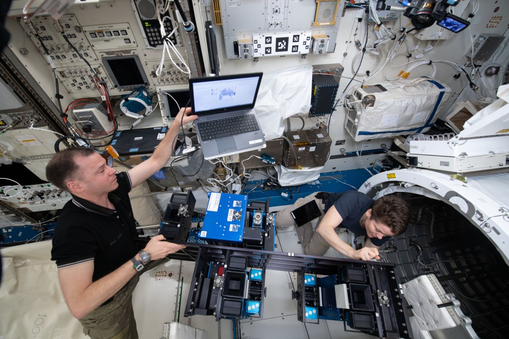 NASA astronauts Nick Hague and Anne McClain install the Materials ISS Experiment-Flight Facility (MISSE-FF) gear inside the Japanese Kibo laboratory module’s airlock before depressurizing the unit. MISSE-FF contains new materials exposure experiments ready for deployment outside Kibo. The study will help scientists understand how radiation, the vacuum of space and micrometeoroids affect a variety of materials.