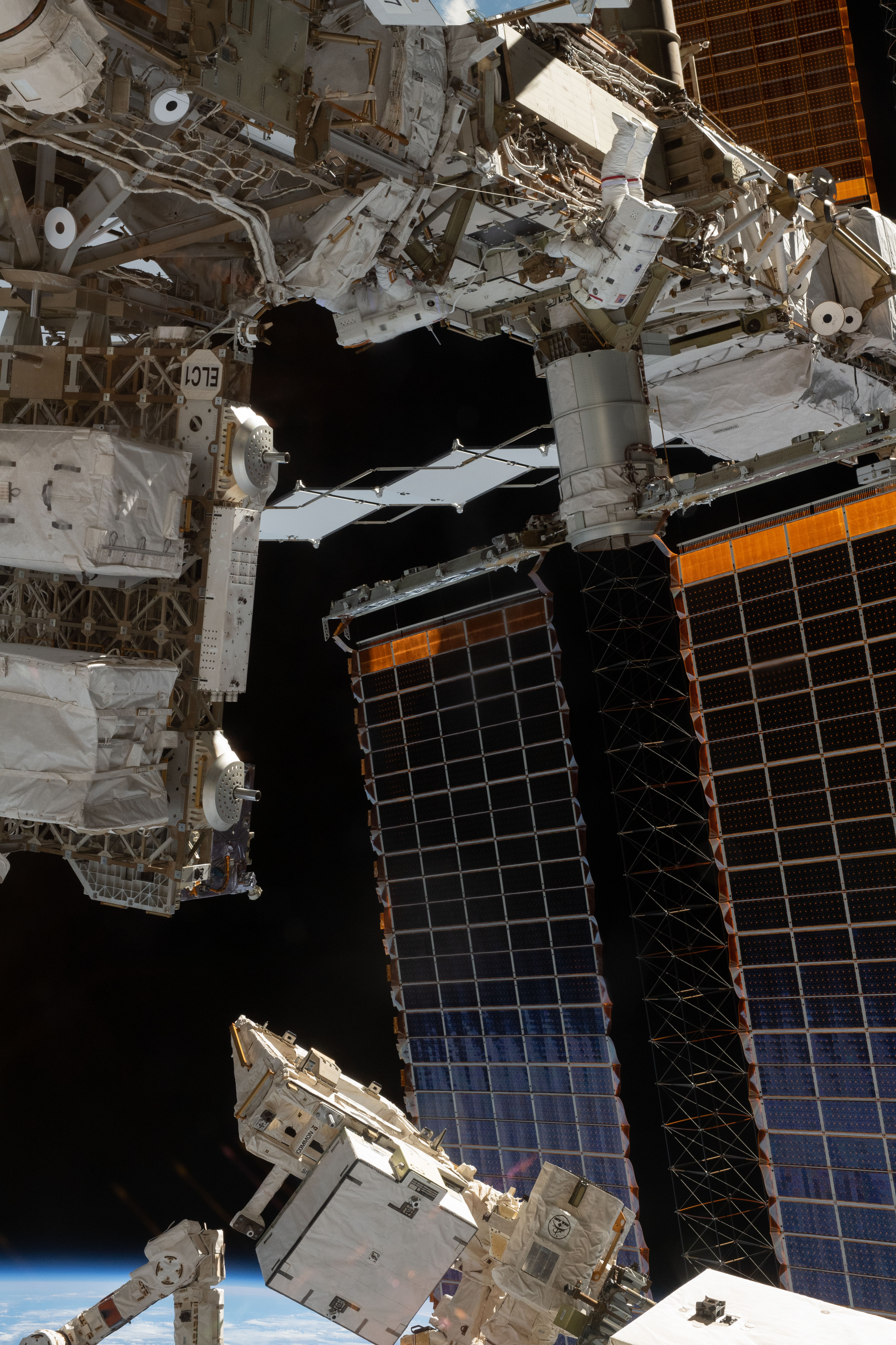 NASA astronaut Anne McClain (at top), in her white U.S. spacesuit with red stripes, is tethered to the International Space Station's Port-4 truss structure during a six-hour, 39-minute spacewalk to upgrade the International Space Station's power storage capacity. This was McClain's and NASA astronaut Nick Hague's (out of frame) first spacewalk.