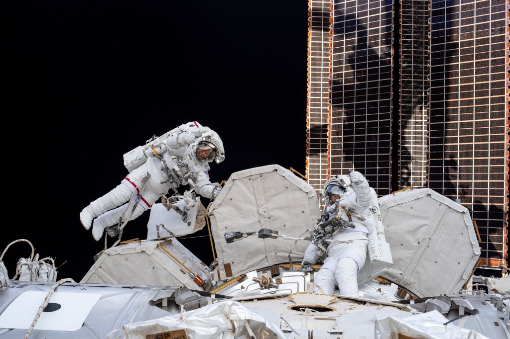 NASA spacewalkers (from left) Bob Behnken and Chris Cassidy give a thumbs up during a spacewalk to install hardware and upgrade International Space Station systems. This photograph was taken by an Expedition 63 crew member inside the cupola, the orbiting lab's "window to the world."