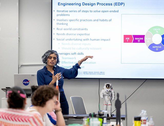 Woman standing in front of a projection screen giving a presentation demonstrating educator professional development