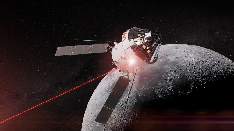 An artist’s illustration of NASA’s Orion spacecraft, a silver and white spaceship with four solar panels, flying through space. A glowing red beam of light, representing laser communications, is seen projecting from the body of the spacecraft and travels off screen. The shadowed crater-filled surface of the Moon is shown behind the spacecraft. A dark grey space scene covered with subtle stars fills the background.