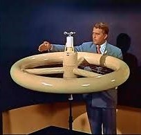 Wernher von Braun demonstrates a model of his wheel-shaped space station in 1956