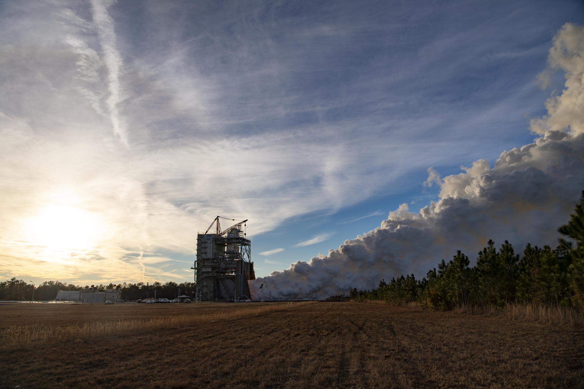 vapor clouds rising into the clouds during a hot fire of an RS-25 engine
