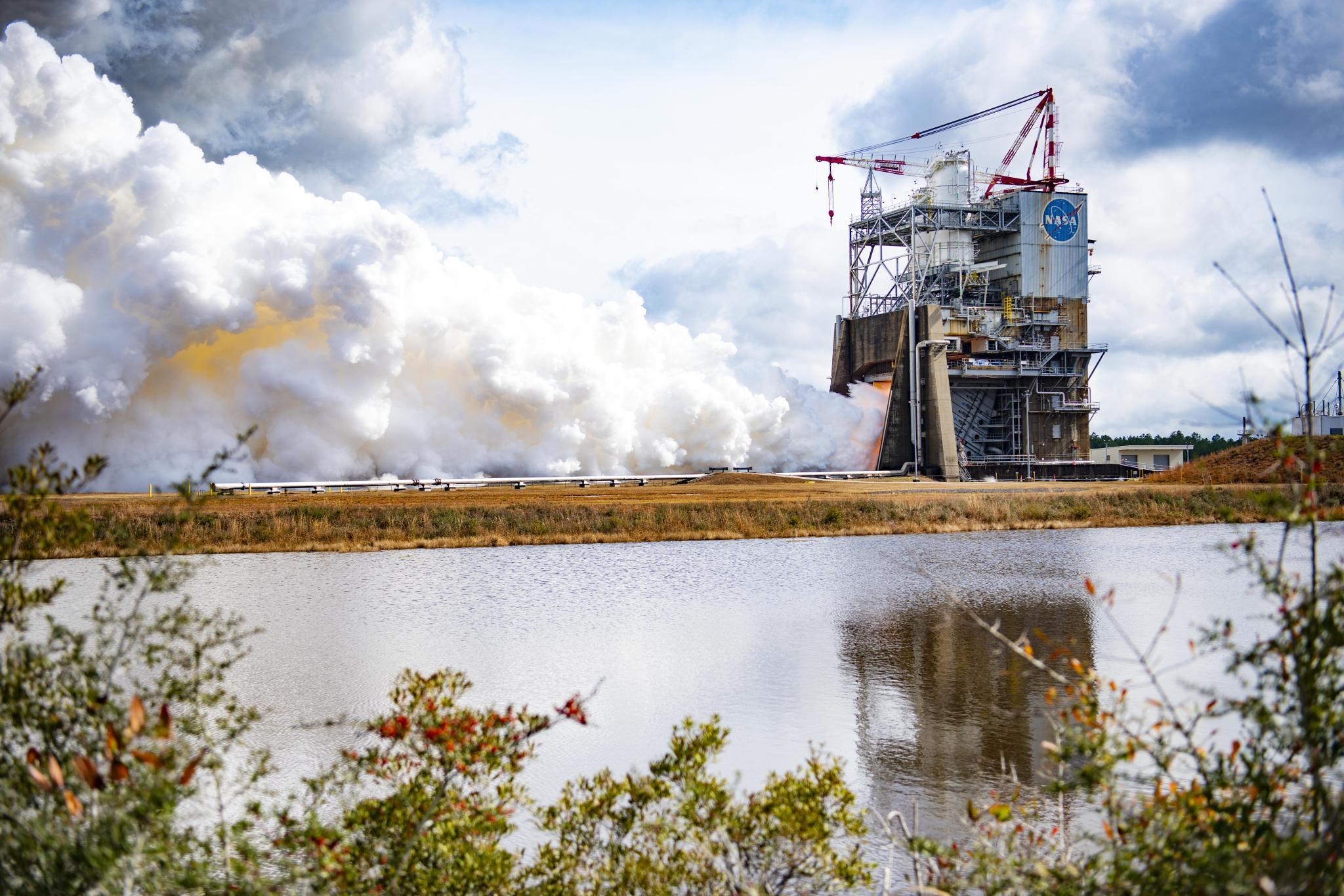 a full-duration, 500-second hot fire of an RS-25 certification engine Jan. 27 ongoing in the background as seen across the water