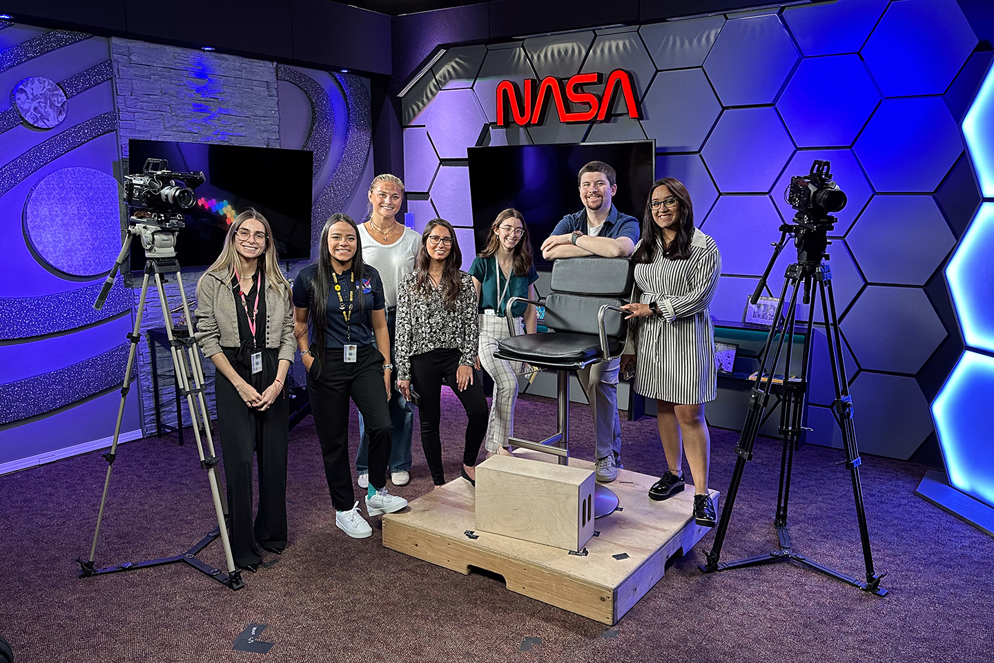 Advice from NASA Mentors. A group of seven interns posing in a NASA tv studio.