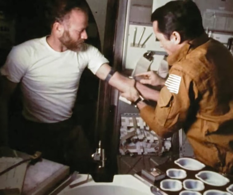 Gibson, right, prepares to draw a blood sample from Carr for a medical experiment
