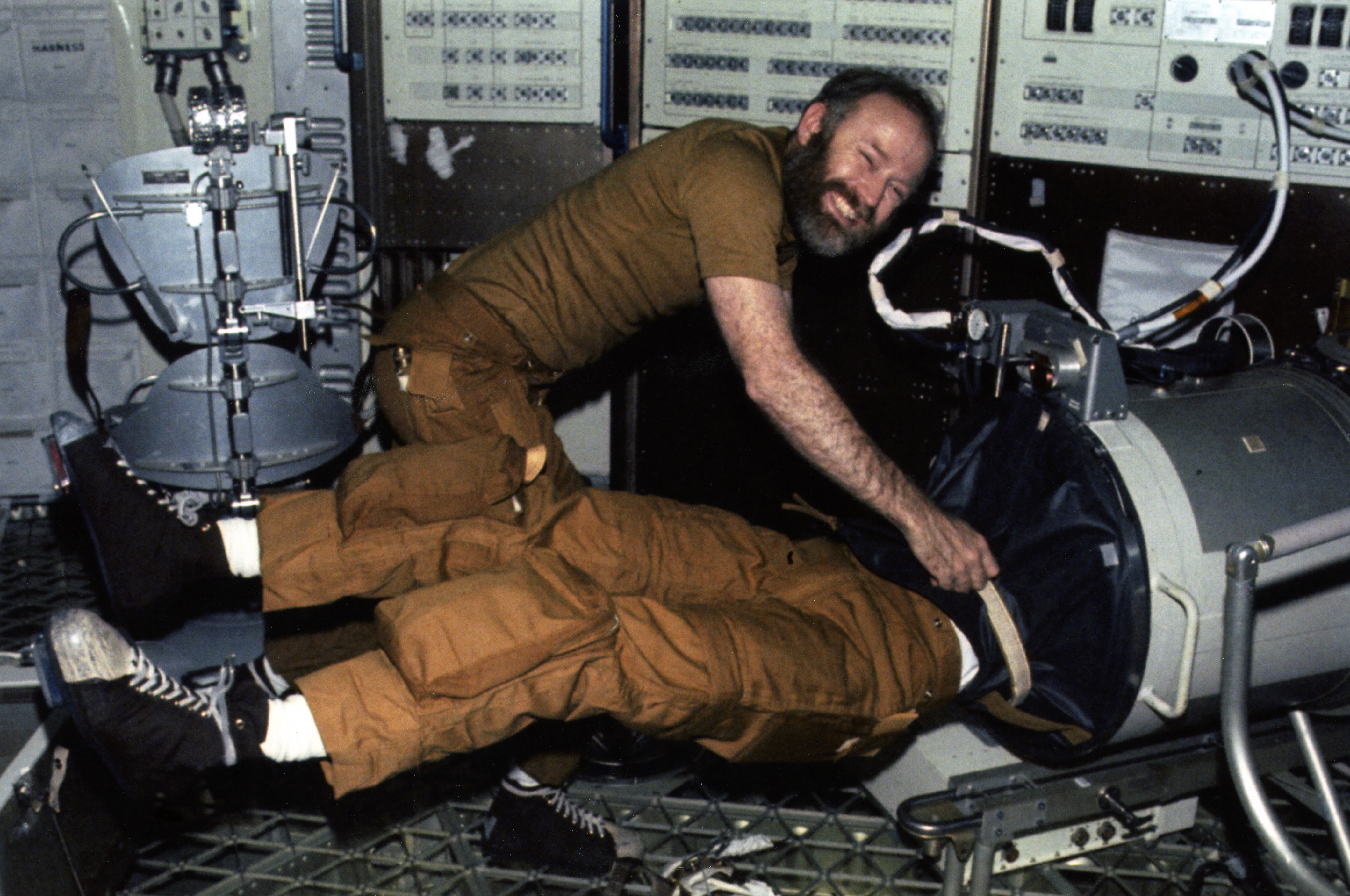 Skylab 4 astronaut Gerald P. Carr conducts an “Upper Body Negative Pressure” test on one of his fellow crew members