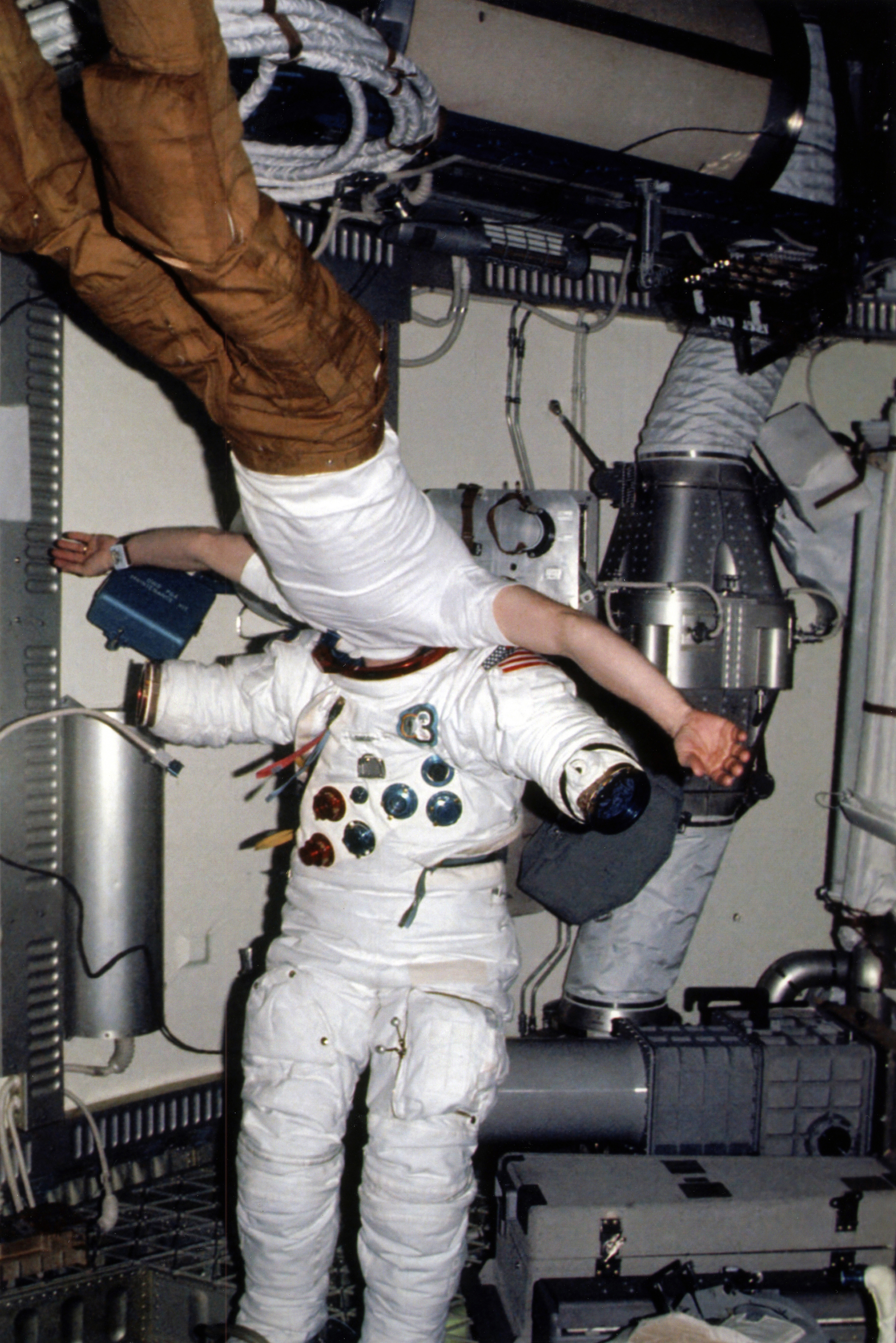 Edward G. Gibson performs an in-depth inspection of his spacesuit