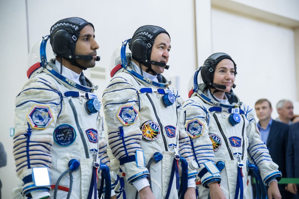 At the Gagarin Cosmonaut Training Center in Star City, Russia, spaceflight participant Hazzaa Ali Almansoori of the United Arab Emirates (left), Oleg Skripochka of Roscosmos (center) and Jessica Meir of NASA (right) report for duty on the second day of crew qualification exams Aug. 30. They will launch Sept. 25 on the Soyuz MS-15 spacecraft from the Baikonur Cosmodrome in Kazakhstan for a mission on the International Space Station.