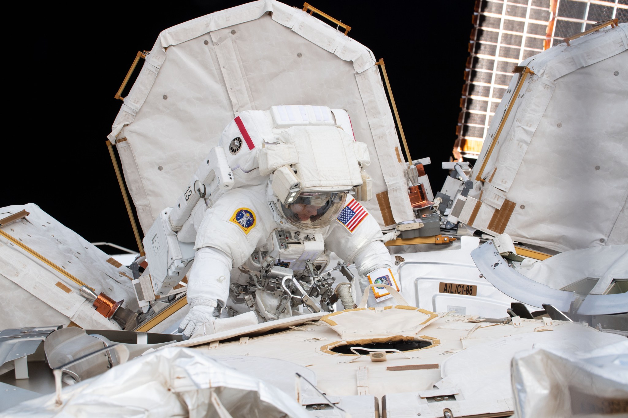 NASA astronaut Anne McClain works outside the U.S. Quest airlock where she exited shortly after beginning a six-hour, 39-minute spacewalk to upgrade the International Space Station's power storage capacity.