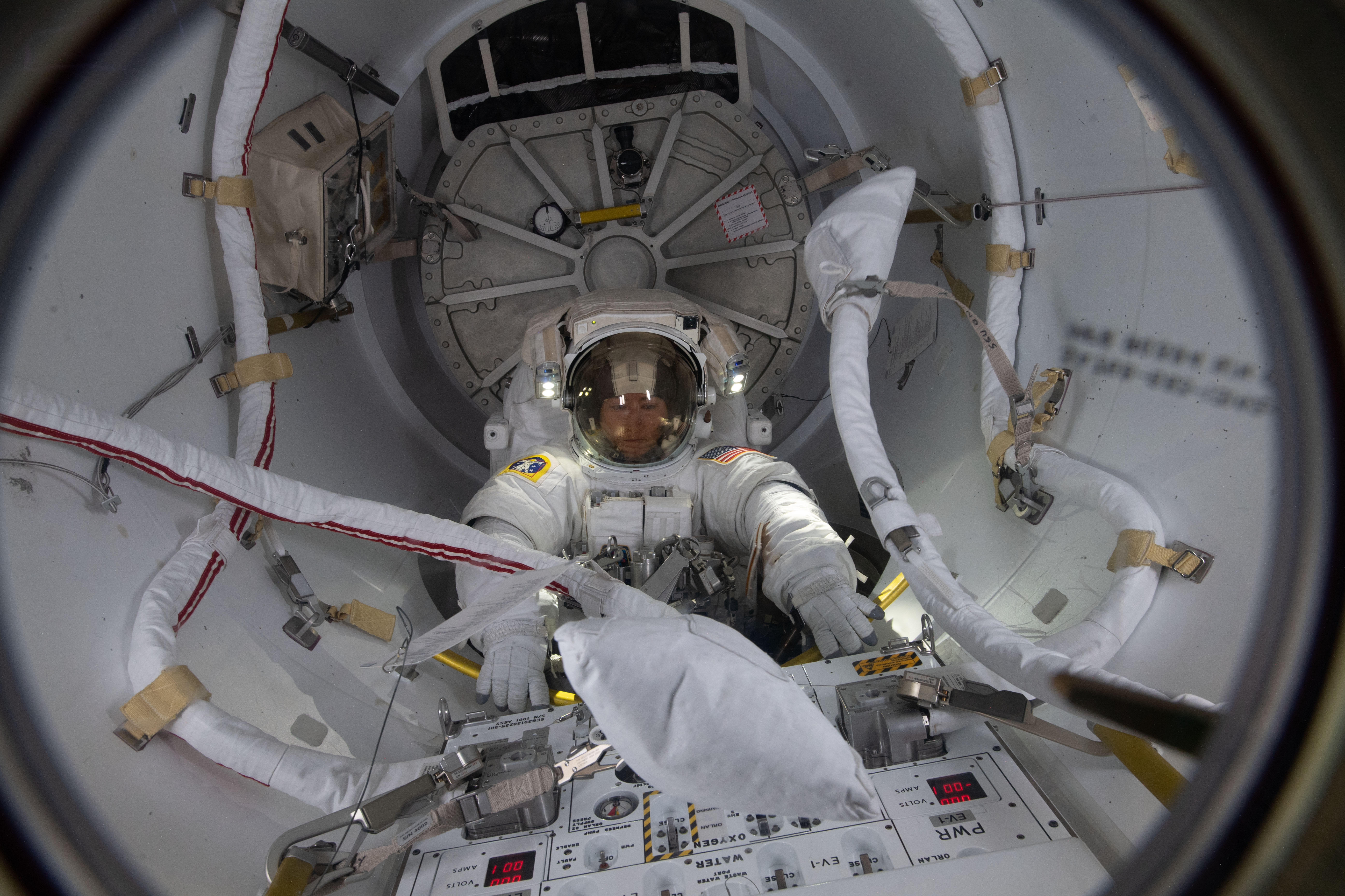 NASA astronaut Christina Koch enters the Quest airlock moments before completing her first spacewalk to upgrade the International Space Station's power storage capacity. She and fellow spacewalker Nick Hague (out of frame) of NASA worked outside in the vacuum of space for six hours and 45 minutes to continue swapping batteries and install adapter plates on the station's Port-4 truss structure.