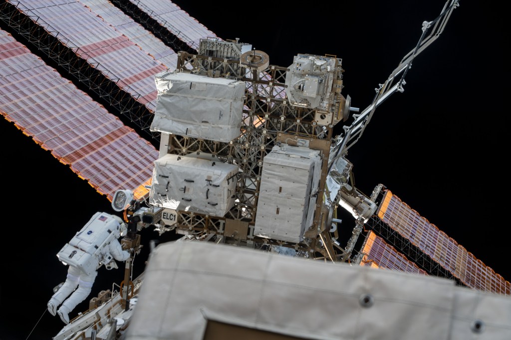 Spacewalker (bottom left) Luca Parmitano works on get-ahead tasks after completing thermal repairs on the Alpha Magnetic Spectrometer, a dark matter and antimatter detector.
