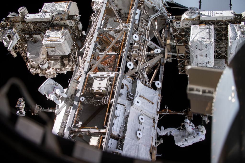 Spacewalkers Andrew Morgan (left) and Luca Parmitano (bottom right) work on get-ahead tasks after completing thermal repairs on the Alpha Magnetic Spectrometer, a dark matter and antimatter detector.