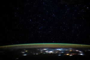 Stars glitter in the night sky above an atmospheric glow that blankets the city lights as the International Space Station orbited 260 miles above northern Iran as it was about to cross the Caspian Sea.