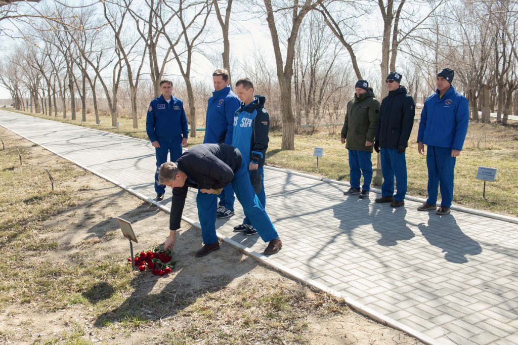 Along the Walk of the Cosmonauts at the Cosmonaut Hotel crew quarters in Baikonur, Kazakhstan, Expedition 63 backup crewmember Steve Bowen of NASA lays flowers March 27 at the site where the tree bearing the name of Yuri Gagarin, the first human to fly in space, is planted. March 27, 2020 marked the 52nd anniversary of Gagarin’s death at the age of 34. Looking on are cosmonaut Yuri Malenchenko, the Deputy Director of the Gagarin Cosmonaut Training Center, and backup crewmates Andrei Babkin and Sergey Ryzhikov of Roscosmos. Looking on at the right are prime crewmembers Chris Cassidy of NASA and Ivan Vagner and Anatoly Ivanishin of Roscosmos who will launch April 9 on the Soyuz MS-16 spacecraft from the Baikonur Cosmodrome in Kazakhstan for a six-and-a-half month mission on the International Space Station.