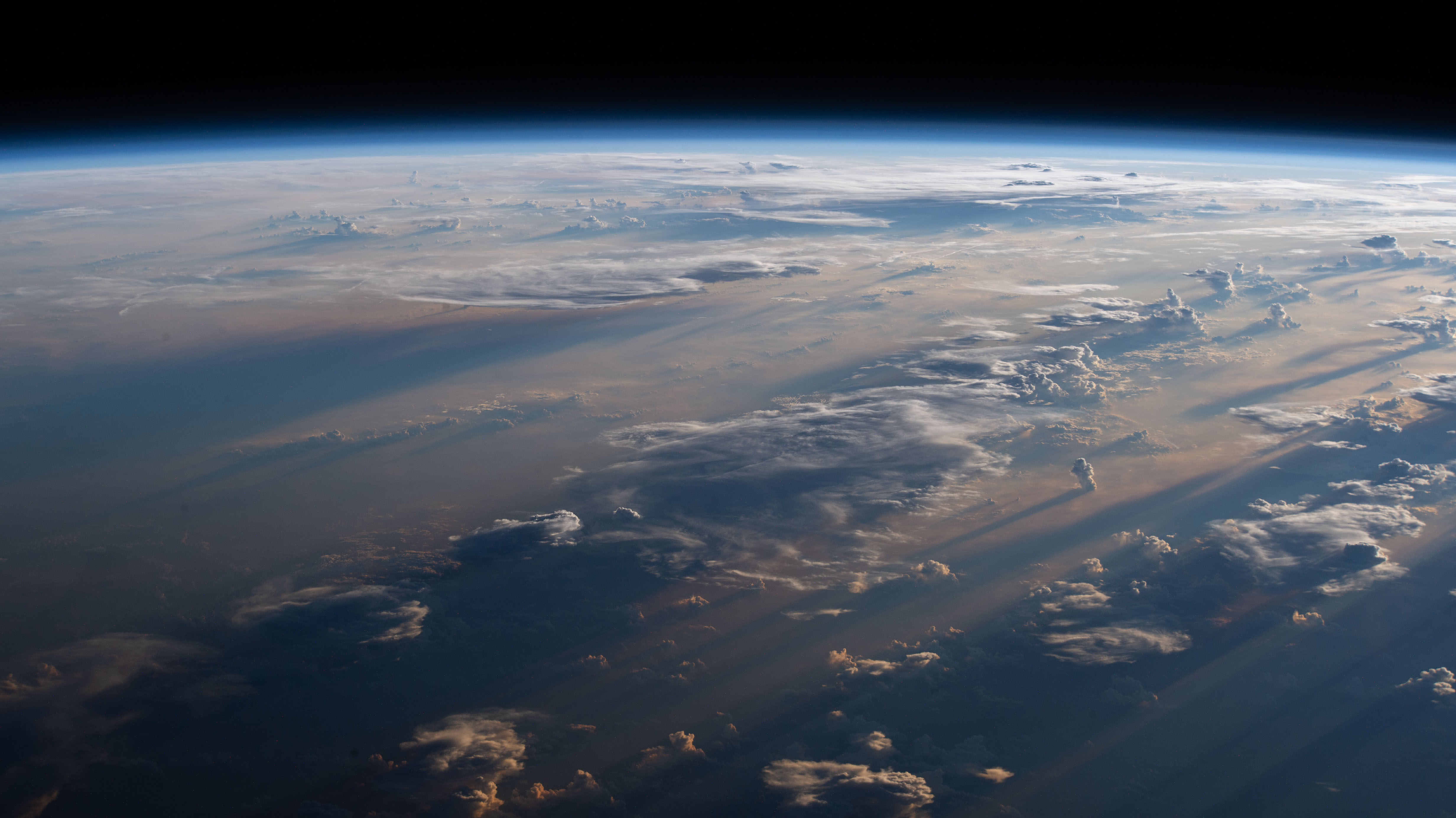 Sunrise casts long shadows over a cloudy Philippine Sea as the International Space Station orbited off the coast of the Philippines northeast of Manila.