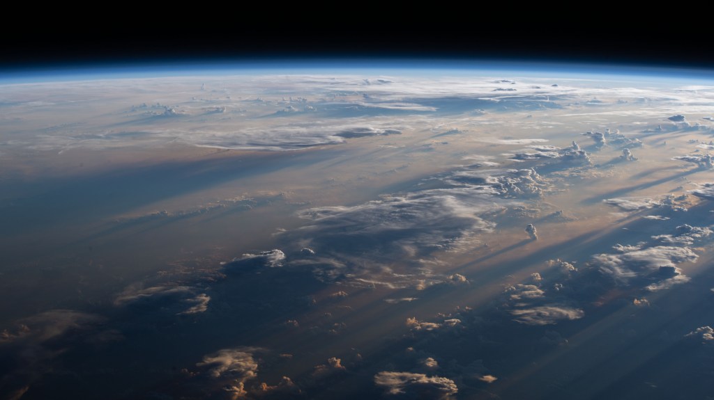 Sunrise casts long shadows over a cloudy Philippine Sea as the International Space Station orbited off the coast of the Philippines northeast of Manila.