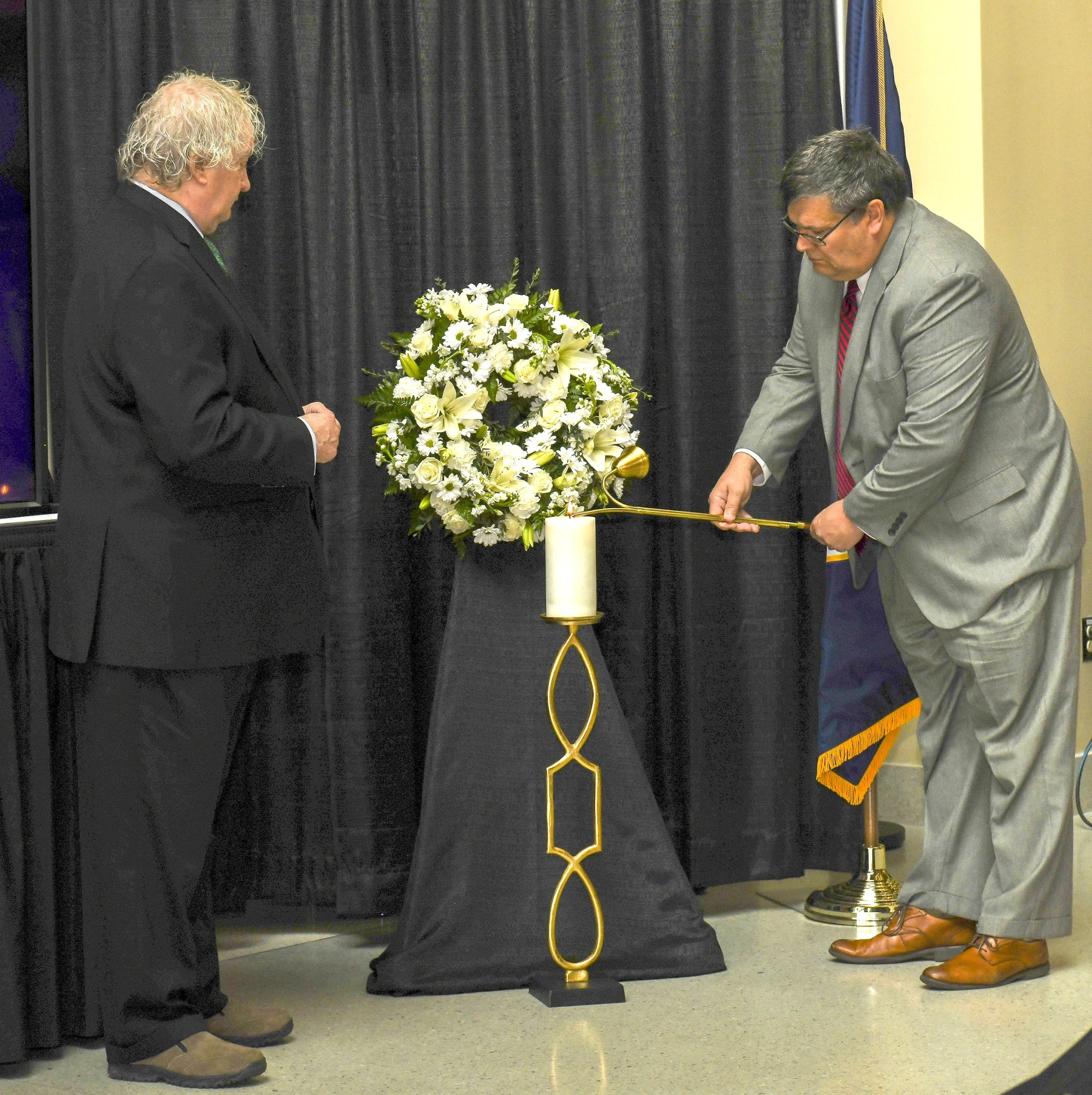 Bill Hill, left, director of Marshall's Safety and Mission Assurance Directorate, observes Larry Leopard, Marshall associate director, technical, lighting a candle in honor of those lost at the Day of Remembrance ceremony.