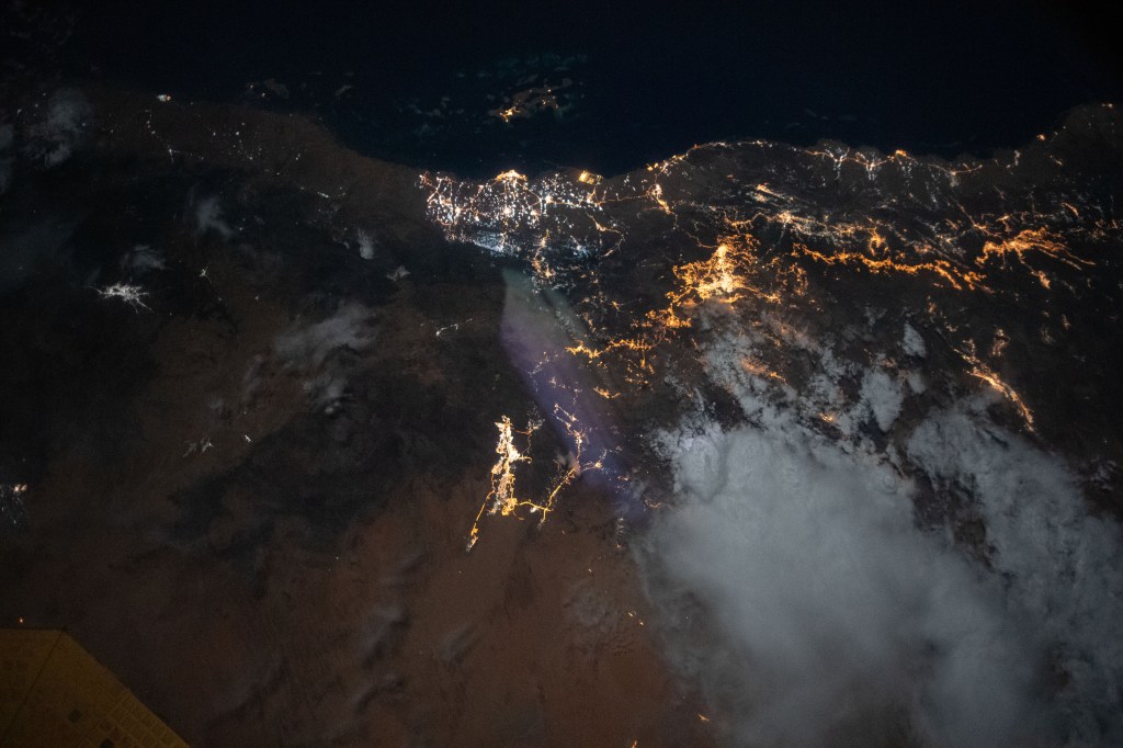The city lights of Jazan (top center) and its suburbs on the Red Sea coast of Saudi Arabia are easily visible from the International Space Station during an orbital night pass. Just off the coast of Jazan is the Farason Island Marine Sanctuary.