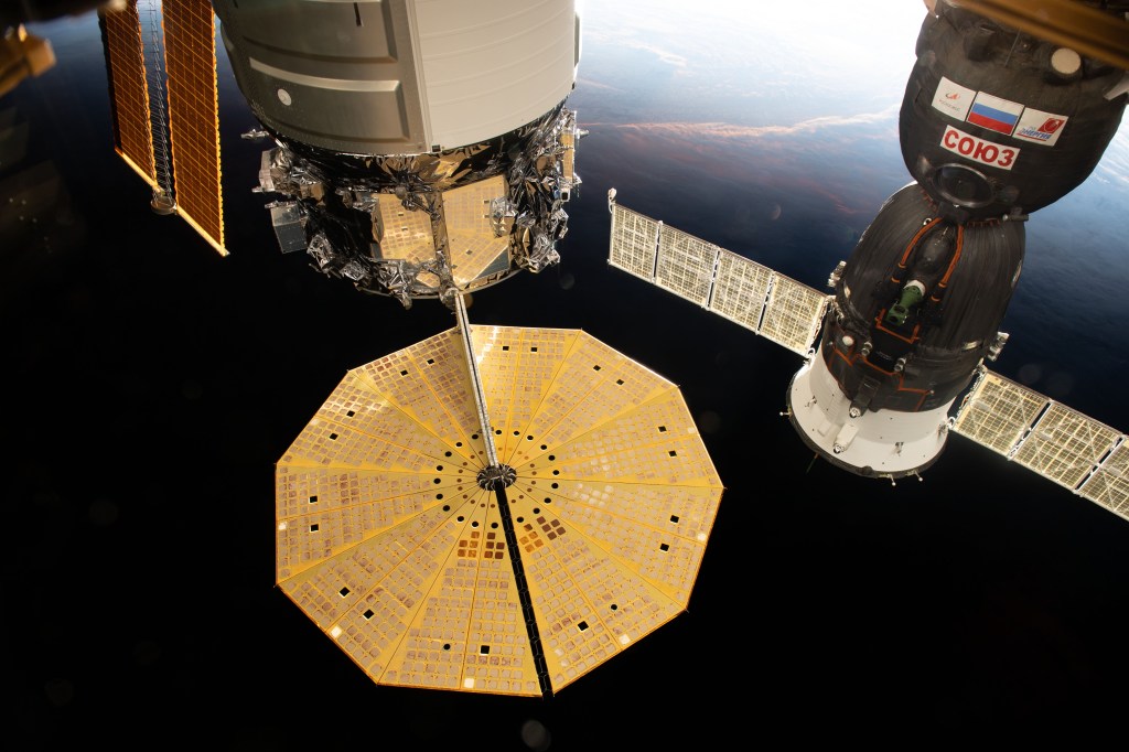 Two spacecraft are pictured docked to the International Space Station as the complex flew into an orbital sunset above the Tasman Sea in between Australia and New Zealand. At left, with its prominent cymbal-shaped UltraFlex solar arrays is the Northrop Grumman's Cygnus resupply ship. To the right, is the Soyuz MS-17 crew ship that docked to the station on Oct. 14 carrying the Expedition 64 crew.