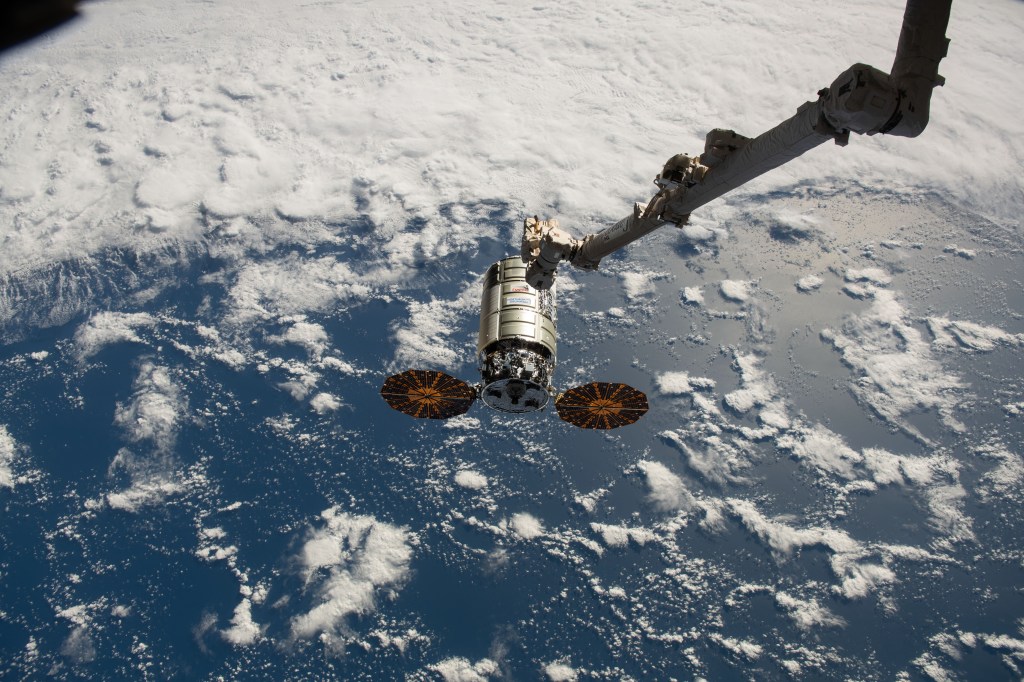 The Northrop Grumman Cygnus space freighter approaches the International Space Station as the Canadarm2 robotic arm is poised to reach out and capture the cargo vehicle.