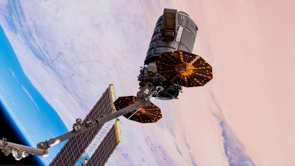The Cygnus space freighter from Northrop Grumman is pictured in the grips of the Canadarm2 robotic arm before its release as the International Space Station orbited above west Africa. Cygnus had completed an 88-day stay attached to the Unity module after delivering nearly 8,200 pounds of research and supplies to the space station on Nov. 4, 2019.