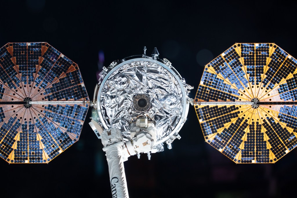 The Cygnus space freighter from Northrop Grumman, with its prominent cymbal-shaped UltraFlex solar arrays, is pictured in the grips of the Canadarm2 robotic arm moments before its release ending its 83-day stay at the International Space Station.