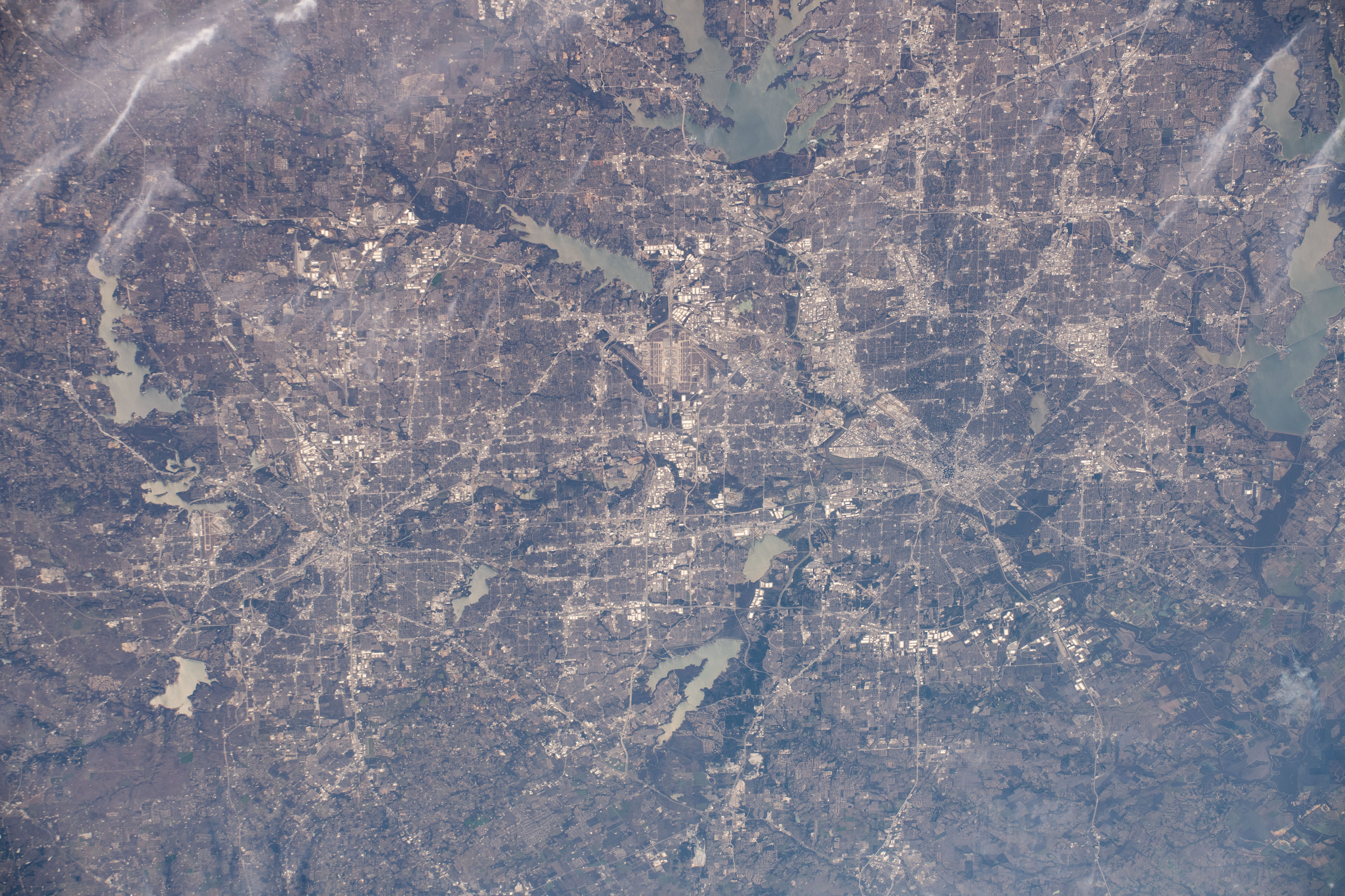 The Dallas-Fort Worth, Texas metropolitan area is pictured along with such landmarks as DFW International Airport and Dallas Love Field Airport from an altitude of 258 miles. Several bodies of water are pictured including Joe Pool Lake, Mountain Creek Lake, White Rock Lake, Lake Ray Hubbard, Lewisville Lake and Grapevine Lake among others.