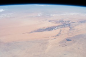 This oblique view from 255 miles above northwest Africa, looking from north to south, shows the "Eye of Sahara" in Mauritania. The circular geologic feature, also known as the Richat Structure, is thought to be caused by an uplifted dome—geologists would classify it as a domed anticline—that has been eroded to expose the originally flat rock layers.