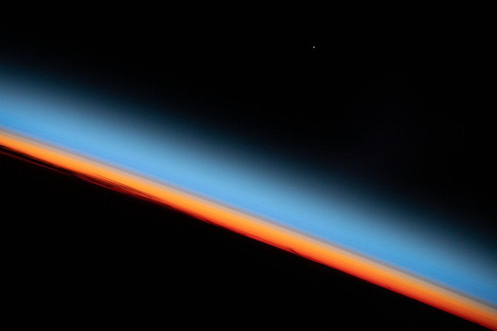 The first rays of an orbital sunrise shine illuminates the Earth's limb and highlights the atmosphere as the International Space Station orbits 259 miles above the central United States.