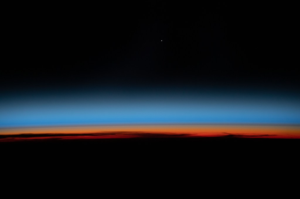 The first rays of an orbital sunrise shine illuminates the Earth's limb and highlights the atmosphere as the International Space Station orbits 259 miles above the central United States.