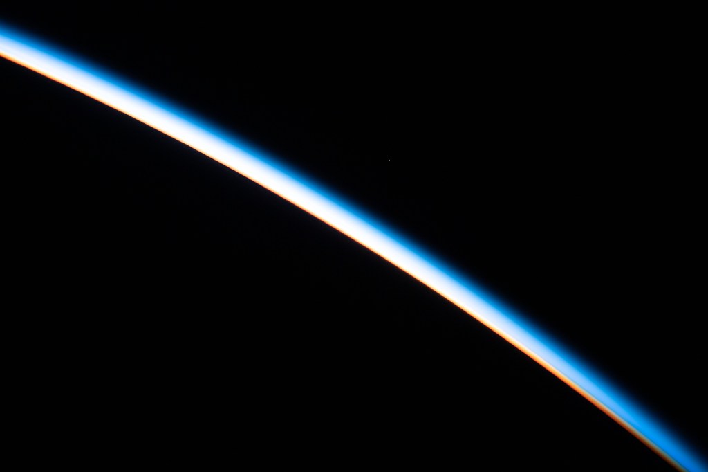 The first rays of an orbital sunrise illuminates the Earth's limb and highlights the atmosphere as the International Space Station orbits 260 miles above the Atlantic Ocean.