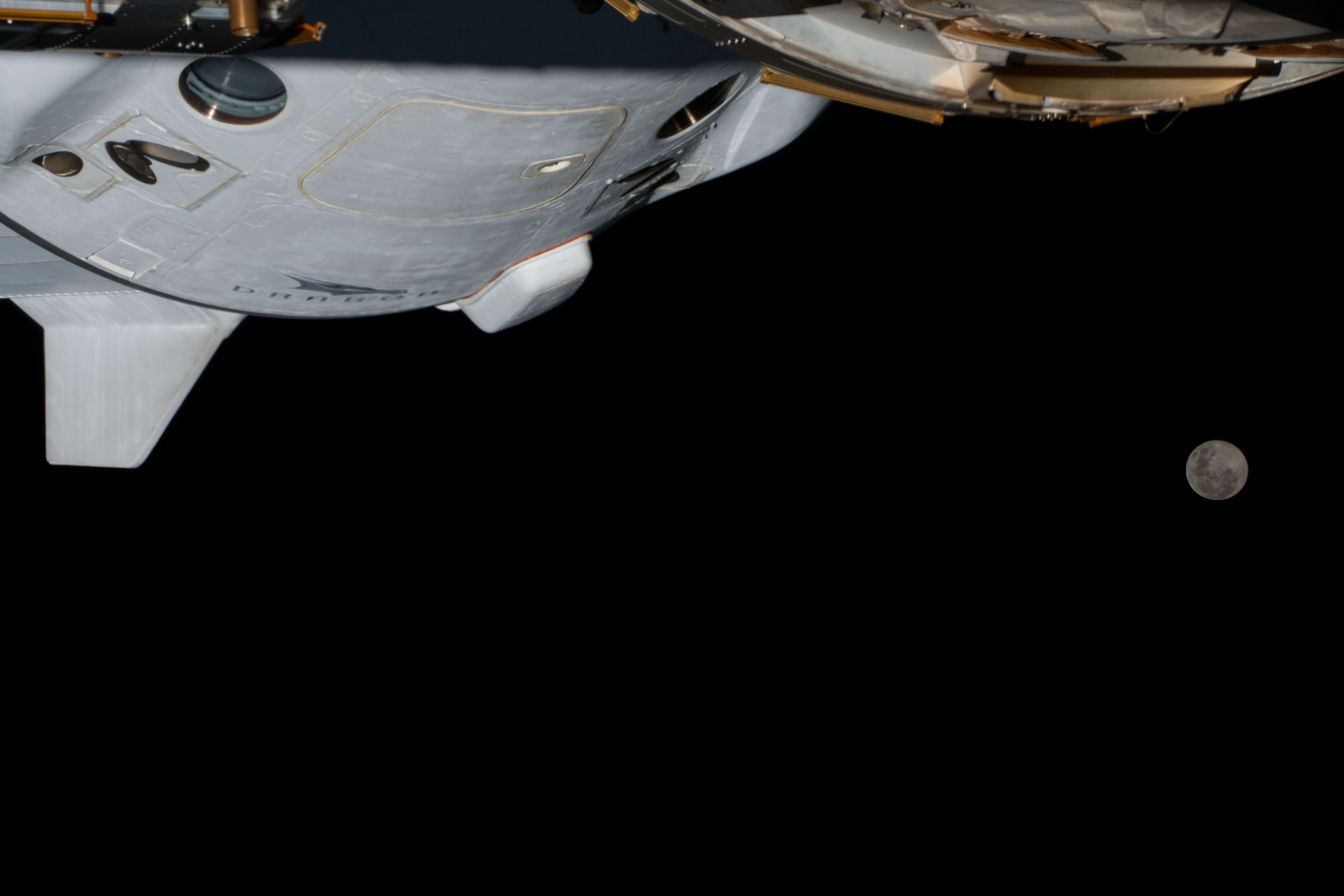 iss068e039227 (Jan. 6, 2023) --- The Full Moon is pictured from the International Space Station along with a portion the SpaceX Dragon Endurance crew ship while orbiting 264 miles above southern Brazil.