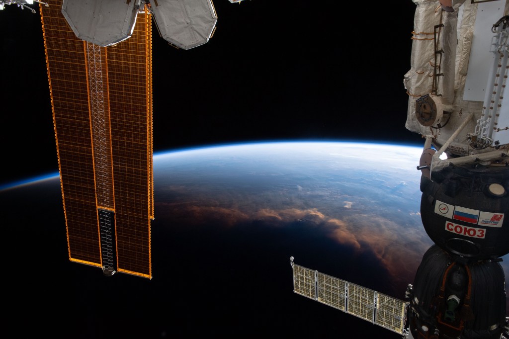 The International Space Station crosses the terminator, the line that separates night and day on Earth, as it orbits 254 miles above the Gulf of Guinea on Africa's mid-western coast. Portions of the orbital complex can be seen including a pair of high-pressure gas tanks, solar arrays and the Soyuz MS-12 crew ship docked to the Rassvet module.
