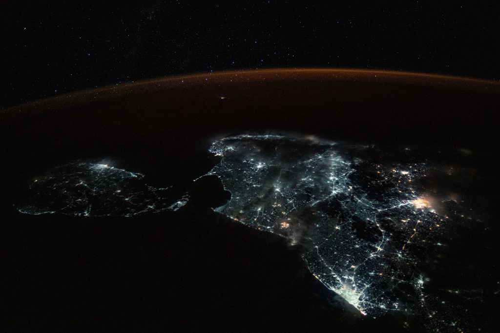 The island nation of Sri Lanka and the brightly-lit southern tip of India feature in this photograph from the International Space Station. This portion of the Indian sub-continent is surrounded by three major water bodies including the Laccadive Sea to the west, the Indian Ocean to the south and Bay of Bengal to the east. A starry sky and an atmospheric glow frame the Earth's horizon.