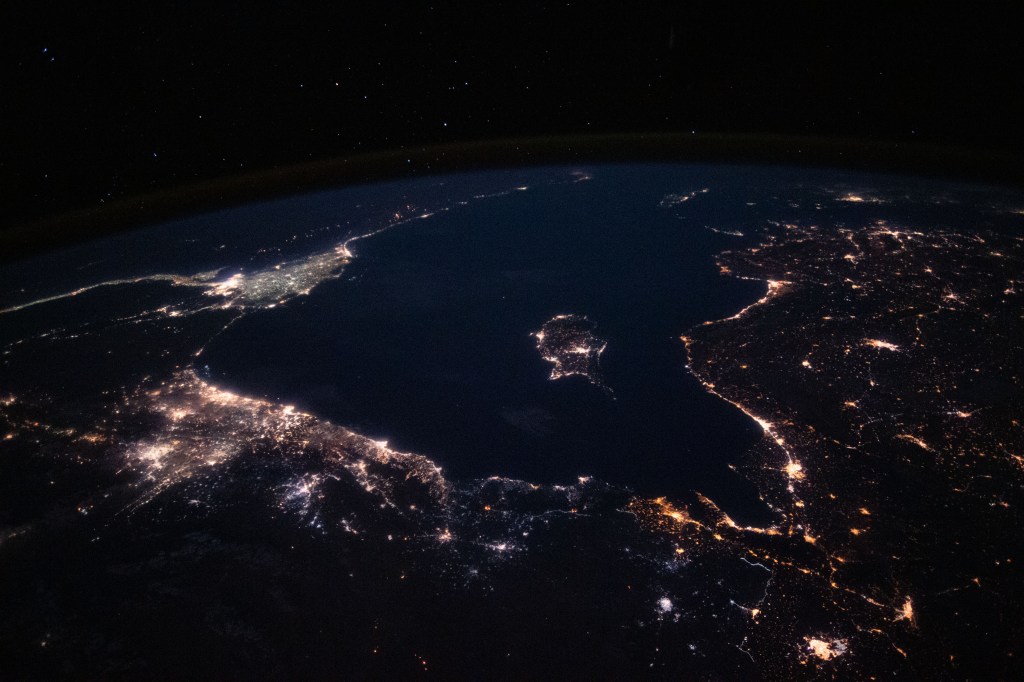 This nighttime view from the International Space Station looks across the Mediterranean Sea ringed by the coastal city lights of southeastern Europe, the Middle East and north Africa.