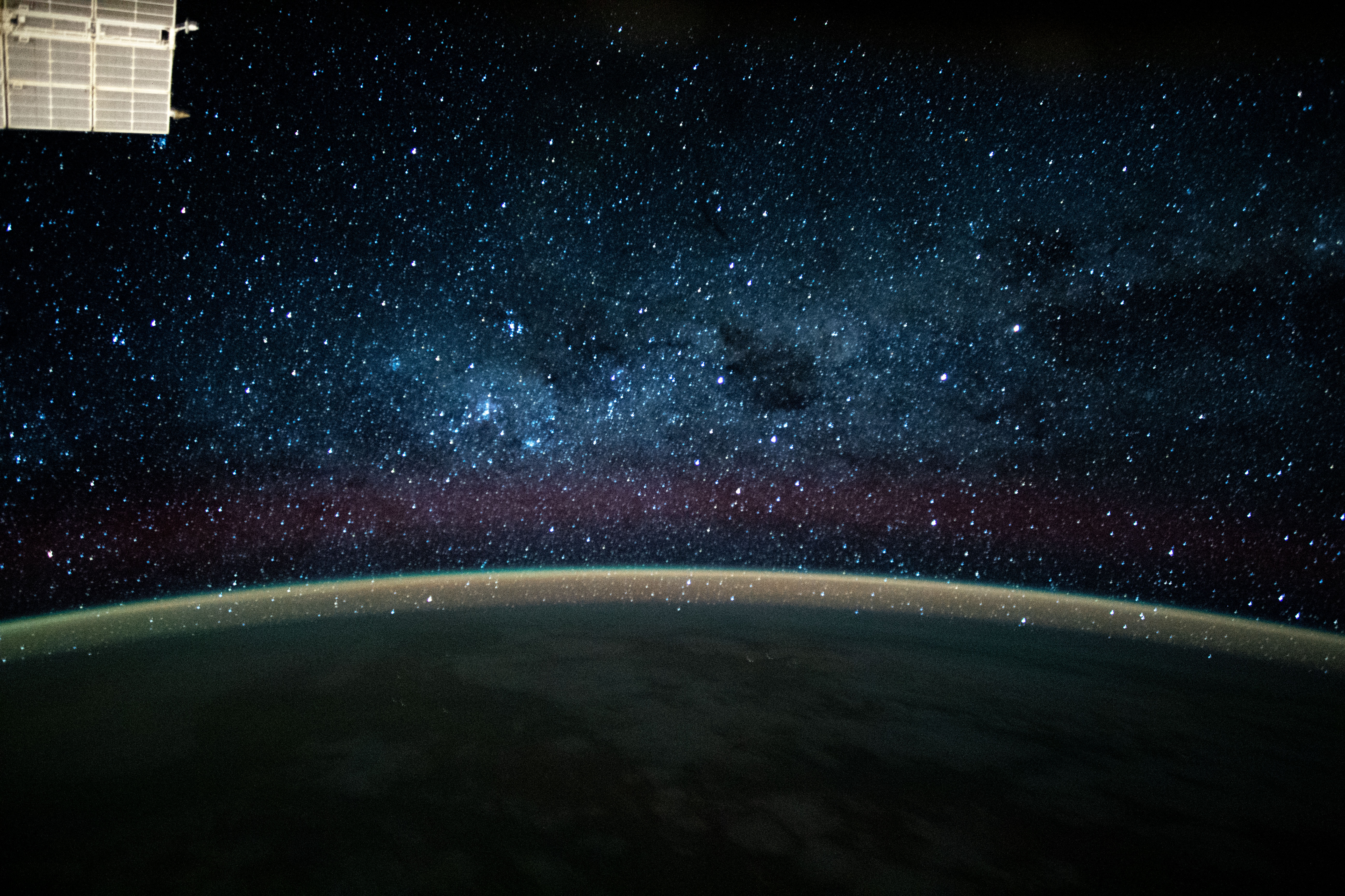 This long-exposure photograph during an orbital night period from the International Space Station reveals a wispy, but colorful atmospheric glow crowning Earth's horizon back-dropped by the dazzling Milky Way.