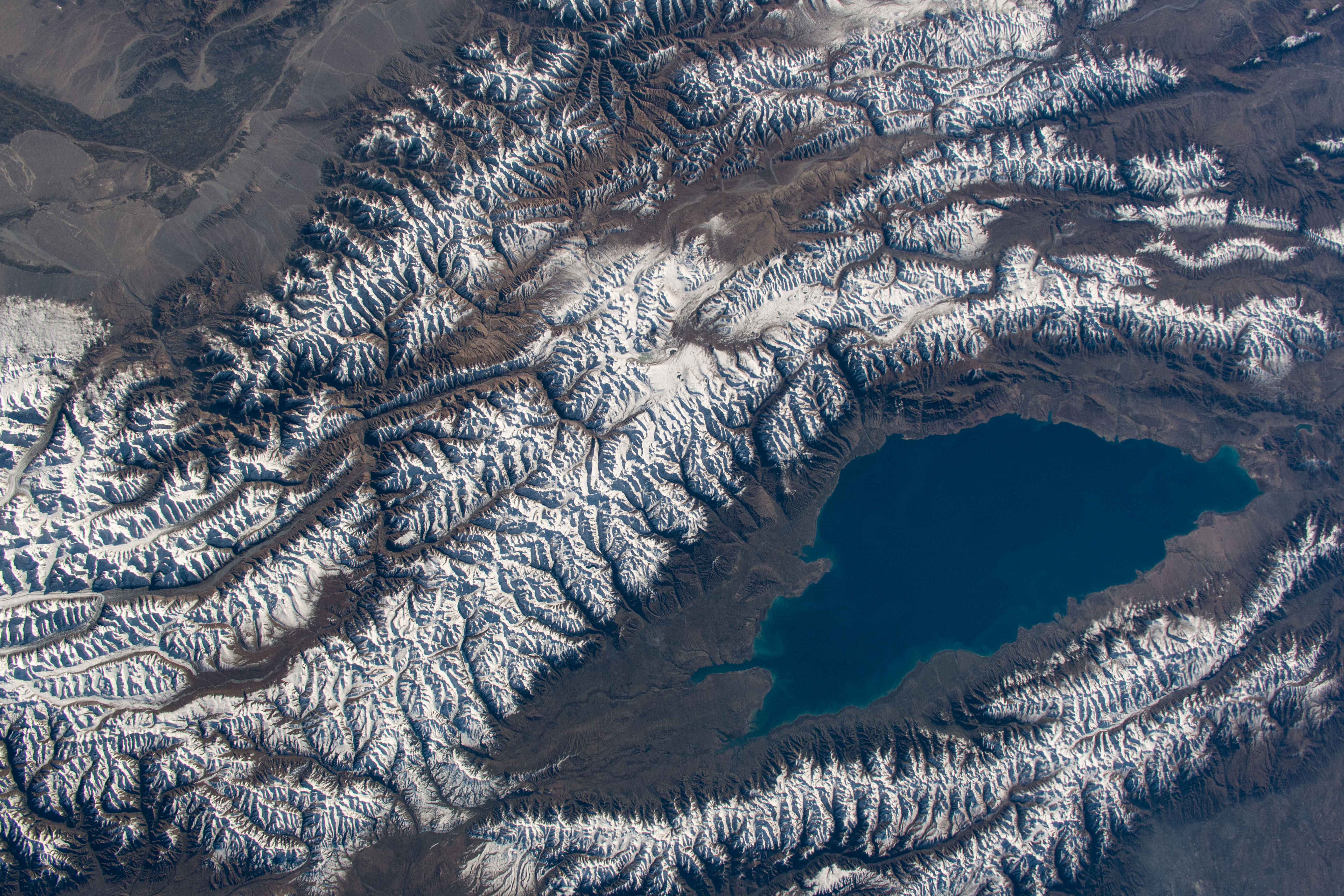 Issyk-Kul Lake in the central Asian nation of Kyrgyzstan is surrounded by the snow-capped Tian Shen mountains. It is the second-largest mountain lake in the world behind Lake Titicaca in South America. The International Space Station was orbiting 252 miles above southeastern Kazakhstan with a ground distance of 72 miles from Issykul-Lake when this photograph was taken.