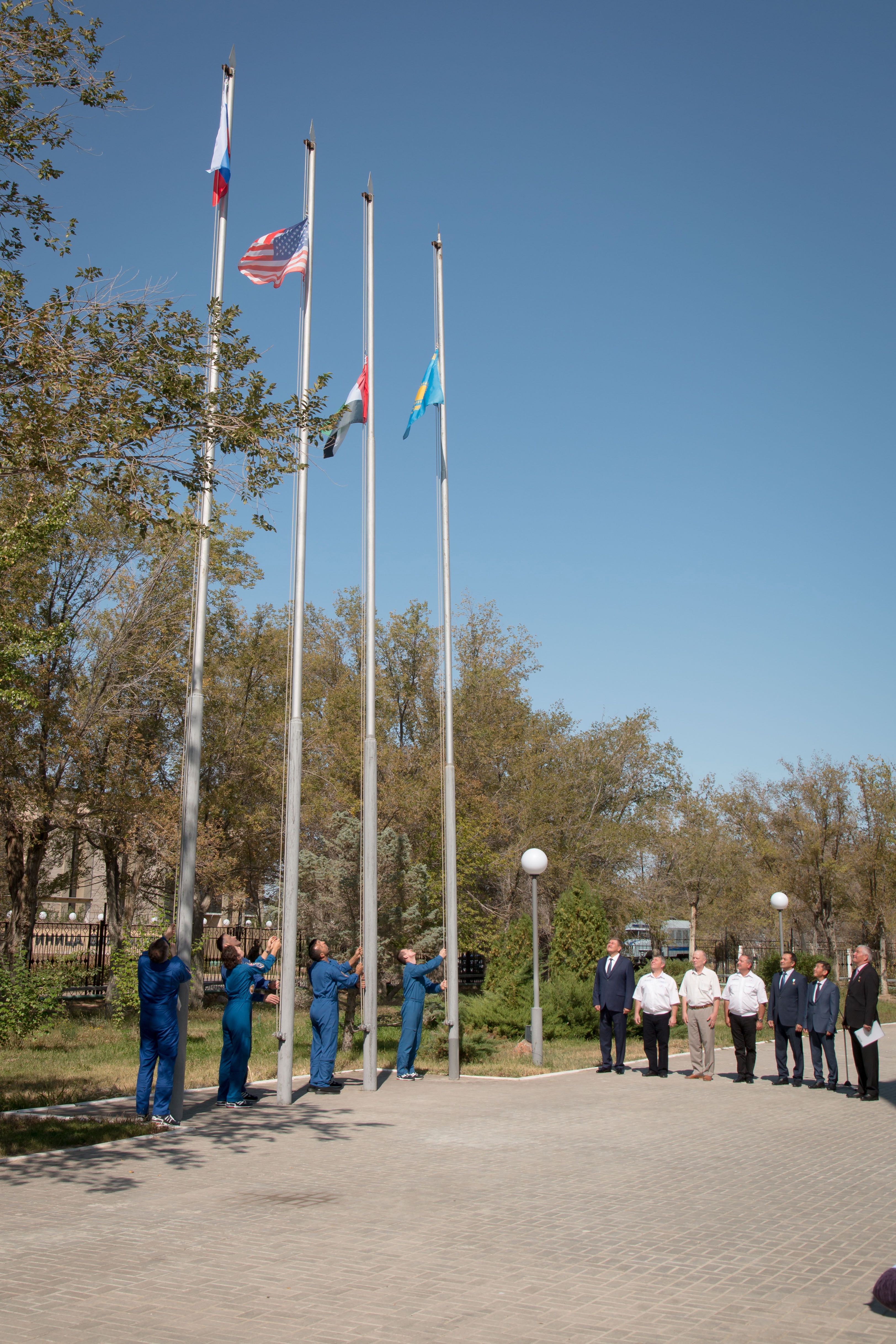 At their Cosmonaut Hotel crew quarters in Baikonur, Kazakhstan, the prime and backup crewmembers for the next launch to the International Space Station raise the flags of Russia, the United States, the United Arab Emirates and Kazakhstan Sept. 12 in a traditional ceremony. Expedition 61 crewmembers Oleg Skripochka of Roscosmos and Jessica Meir of NASA and spaceflight participant Hazzaa Ali Almansoori of the United Arab Emirates will launch Sept. 25 on the Soyuz MS-15 spacecraft for a mission on the International Space Station. Image: NASA/Victor Zelentsov.