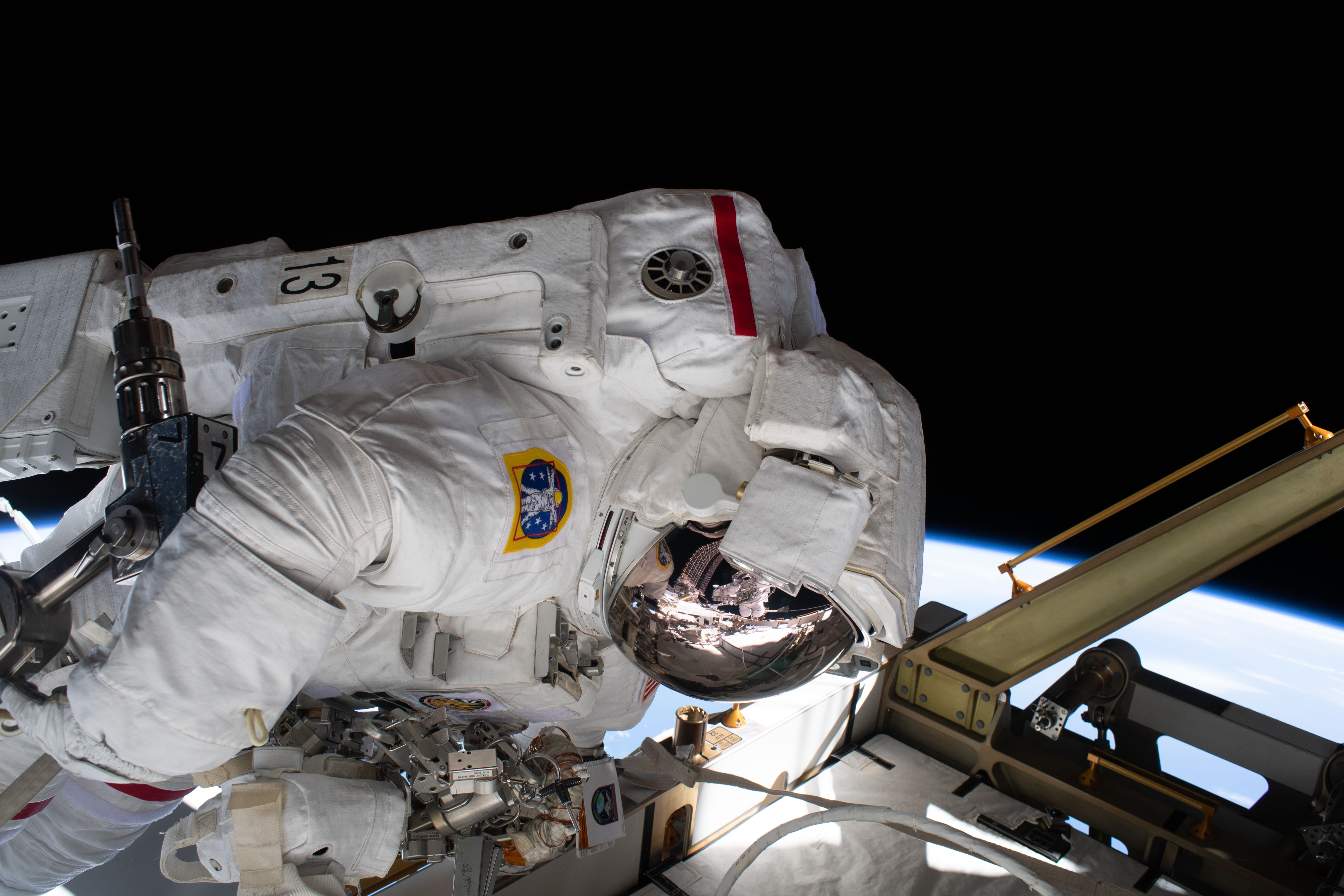 The reflection in NASA astronaut Jessica Meir's spacesuit helmet is fellow NASA astronaut Christina Koch photographing her crewmate during a spacewalk to finalize upgrading power systems on the International Space Station's Port-6 truss structure.