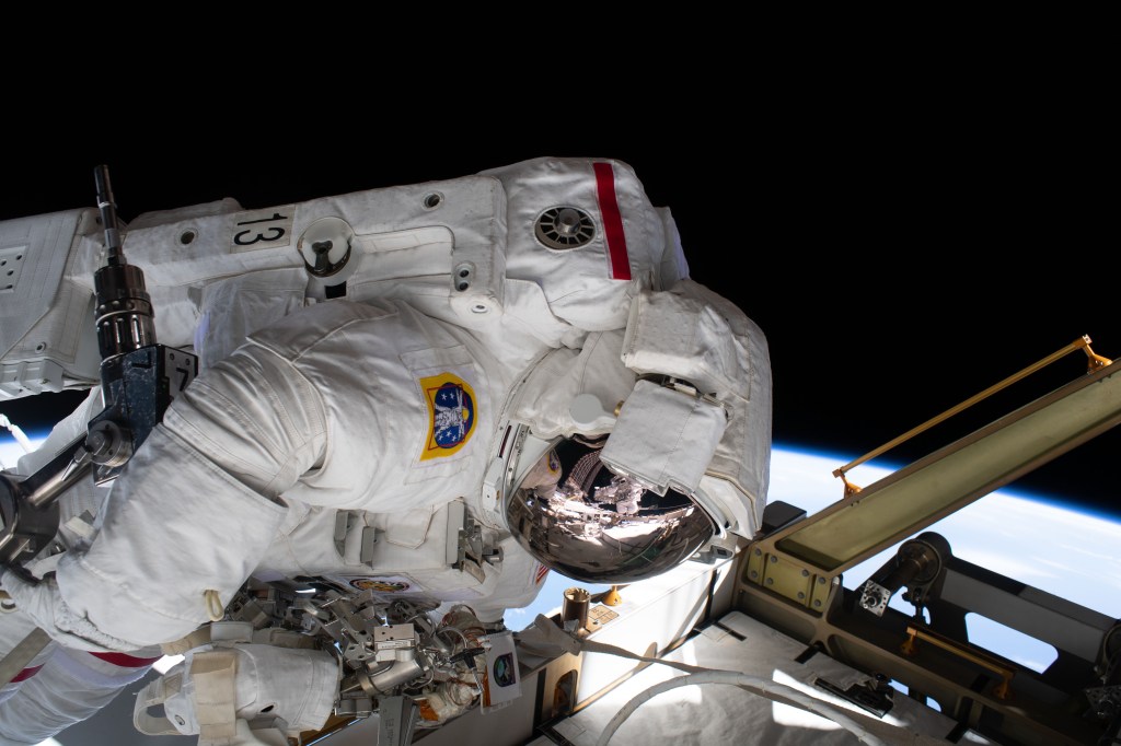 The reflection in NASA astronaut Jessica Meir's spacesuit helmet is fellow NASA astronaut Christina Koch photographing her crewmate during a spacewalk to finalize upgrading power systems on the International Space Station's Port-6 truss structure.